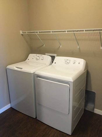 a washer and dryer sit next to each other in a laundry room at Courtyard Apartments, Moorhead, 56560
